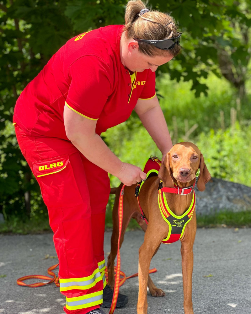 Hundeführerin der DLRG mit einem Rettungshund im Training.